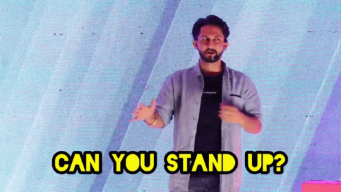 A Man Stands In Front Of A Screen With The Words Can You Stand Up GIF