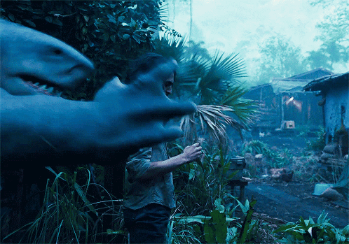 A Man Stands In Front Of A Shark That Is Eating A Palm Tree GIF