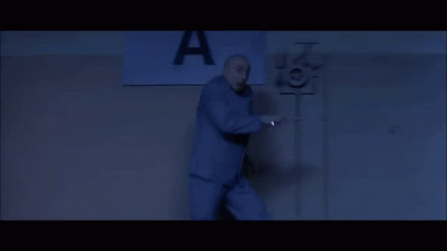 A Man Stands In Front Of A Sign That Says A GIF