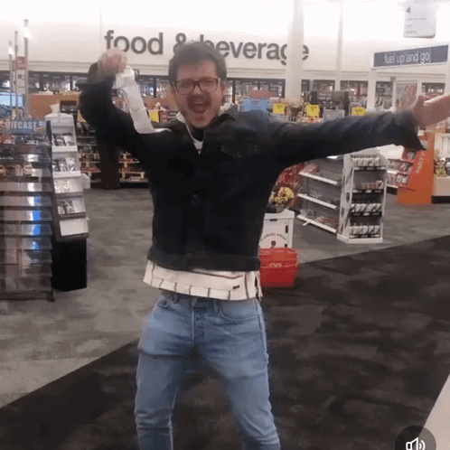A Man Stands In Front Of A Sign That Says Food And Beverage GIF