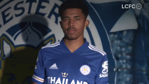 A Man Stands In Front Of A Sign That Says Lcfc On It GIF