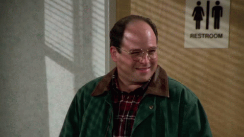 A Man Stands In Front Of A Sign That Says Restroom GIF