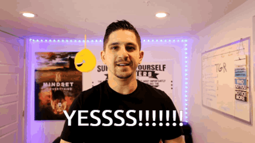 A Man Stands In Front Of A Sign That Says Yesss !!! GIF