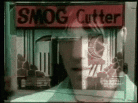 A Man Stands In Front Of A Smog Cutter Shop GIF