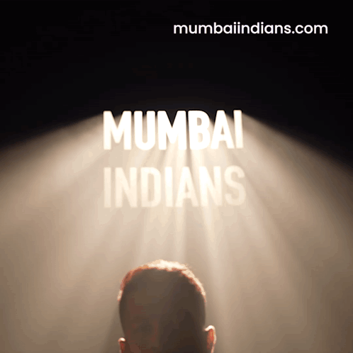 A Man Stands In Front Of A Spotlight That Says Mumbai Indians On It GIF