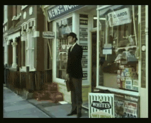 A Man Stands In Front Of A Store That Sells Whites Cigarettes GIF