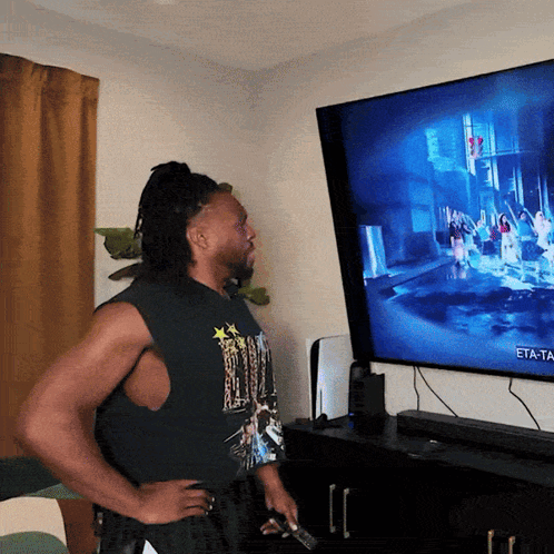 a man stands in front of a tv that says eta-ta