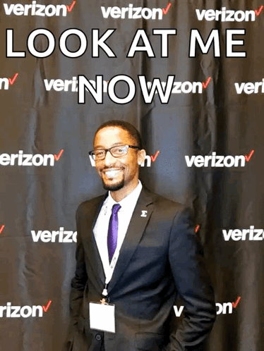A Man Stands In Front Of A Verizon Banner GIF