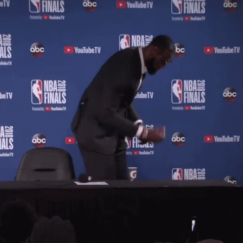 a man stands in front of a wall that says nba finals on it