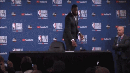 a man stands in front of a wall that says nba finals on it