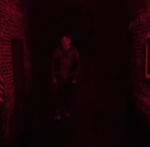 a man stands in front of a wall that says unmask the truth on it