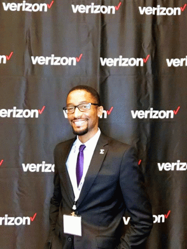 A Man Stands In Front Of A Wall That Says Verizon GIF