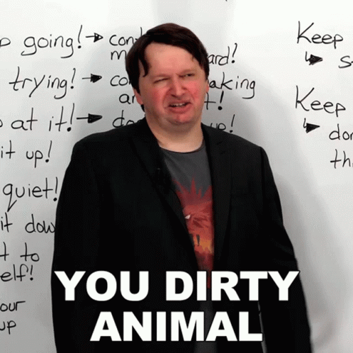 A Man Stands In Front Of A White Board That Says " You Dirty Animal " On It GIF