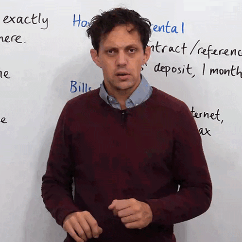 A Man Stands In Front Of A White Board With The Words Exactly Written On It GIF