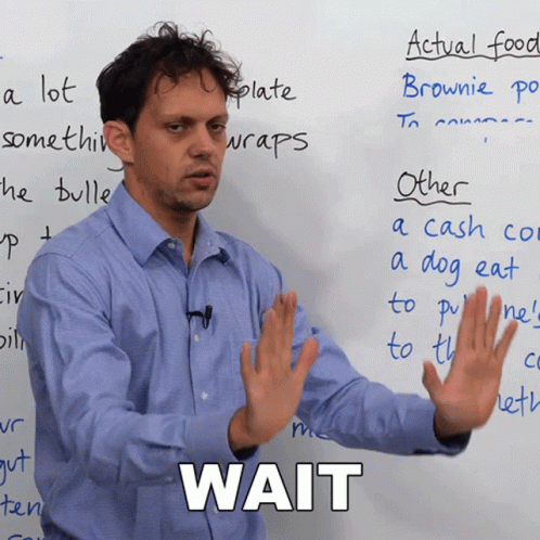 A Man Stands In Front Of A Whiteboard With The Word Wait Written On It GIF