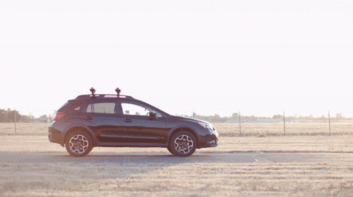 A Man Stands Next To A Black Suv With A Camera On The Roof GIF
