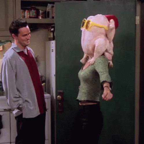 A Man Stands Next To A Woman Wearing A Turkey Head And Sunglasses GIF