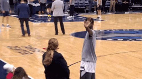 A Man Stands On A Basketball Court In Front Of A Sign That Says Mavericks GIF