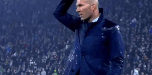 A Man Stands On A Soccer Field In Front Of A Uefa Champions League Advertisement GIF