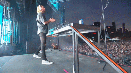 A Man Stands On A Stage In Front Of A Crowd And A Sign That Says ' Chicago Radio ' On It GIF