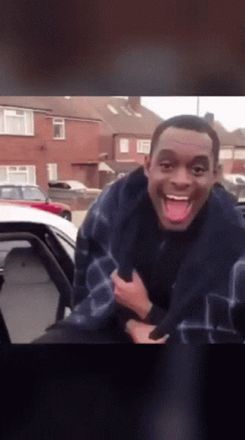A Man Sticking His Tongue Out While Sitting In The Back Of A Car GIF