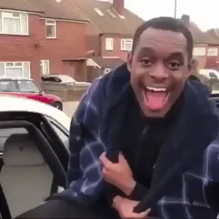 A Man Sticking His Tongue Out While Sitting In The Back Seat Of A Car GIF