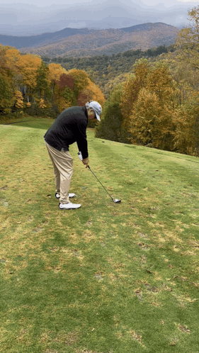 A Man Swings A Golf Club On A Golf Course GIF