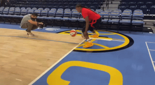 A Man Taking A Picture Of A Basketball Player On A Court GIF