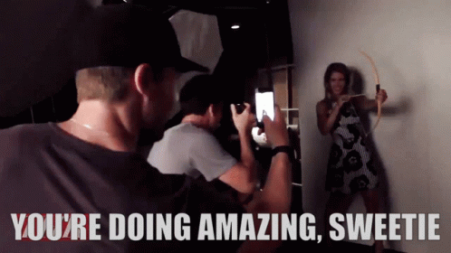 A Man Taking A Picture Of A Woman With The Words You 'Re Doing Amazing Sweetie Behind Him GIF