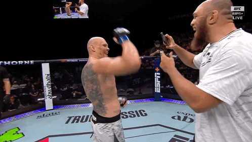 A Man Taking A Picture Of Another Man In A Boxing Ring That Says Espn Live GIF