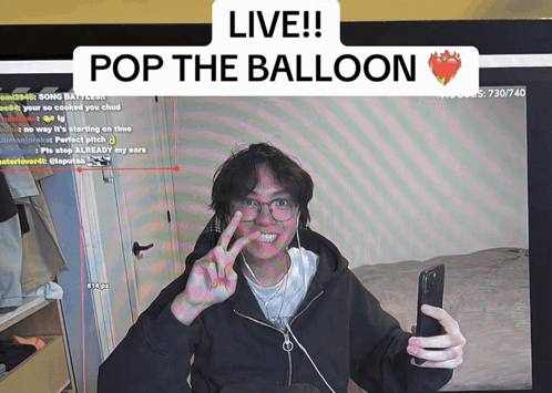 A Man Taking A Selfie In Front Of A Screen That Says " Live Pop The Balloon " GIF