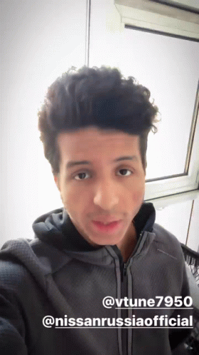 A Man Taking A Selfie In Front Of A Window With The Hashtag @Vtune7950 GIF