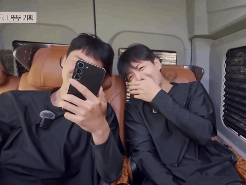 A Man Taking A Selfie With Another Man Covering His Face GIF