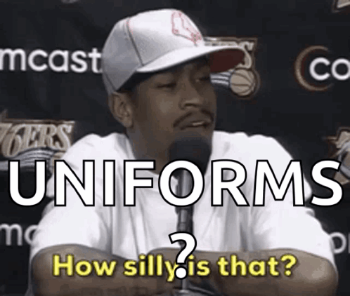 A Man Talking Into A Microphone With The Words Uniforms How Silly Is That Behind Him GIF