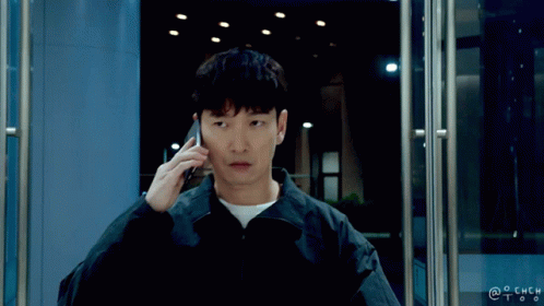A Man Talking On A Cell Phone In Front Of A Door With A Watermark That Says @Chch GIF