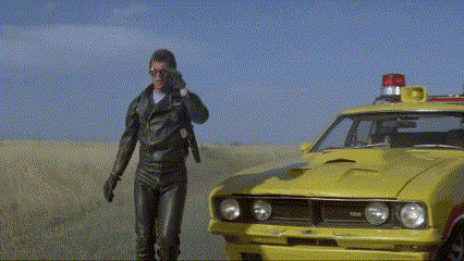 A Man Talking On A Cell Phone Next To A Yellow Car With A Red Light On Top GIF