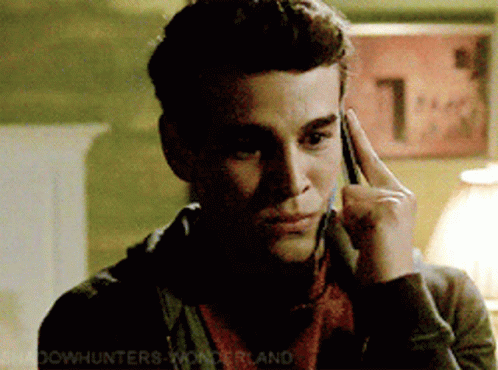A Man Talking On A Cell Phone With A Sign In The Background That Says 1 GIF