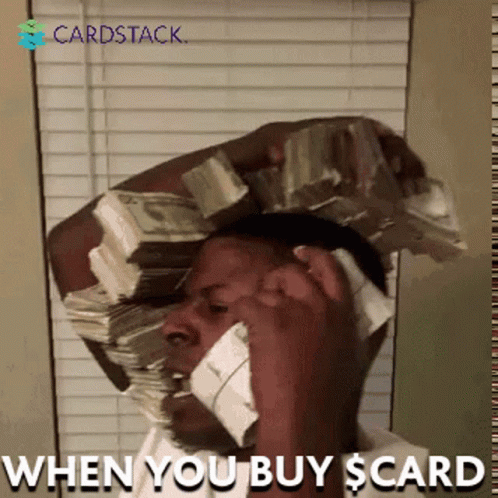 A Man Talking On A Cell Phone With A Stack Of Money On His Head GIF