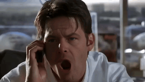 A Man Talking On A Cell Phone With His Mouth Wide Open GIF