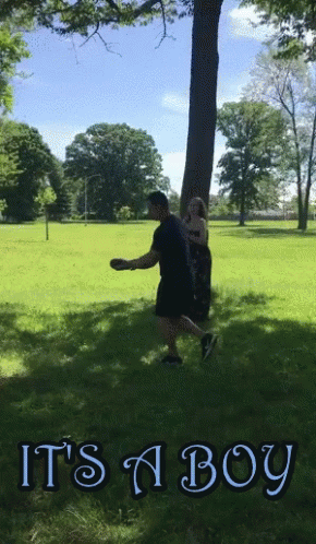 A Man Throws A Frisbee In A Park With The Words It 'S A Boy GIF