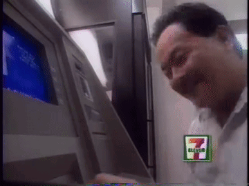 A Man Using An Atm Machine With A 7 Eleven Logo GIF
