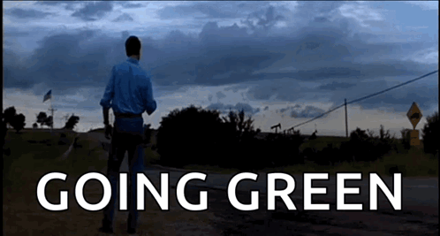 A Man Walking Down A Dirt Road With The Words " Going Green " On The Bottom GIF