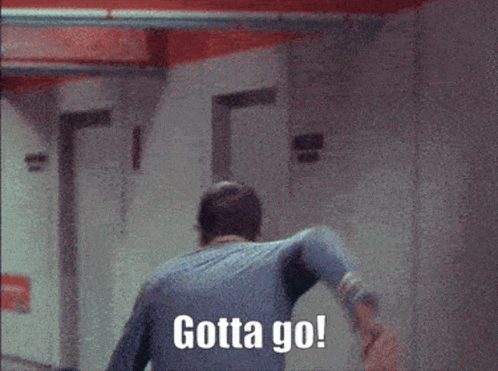 A Man Walking Down A Hallway With Gotta Go Written On The Wall Behind Him GIF