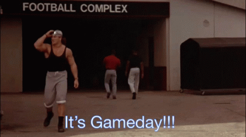 A Man Walking In Front Of A Sign That Says " Football Complex " GIF