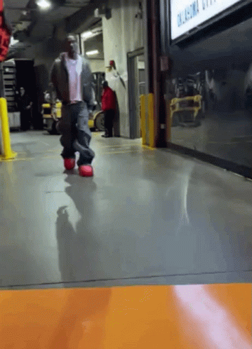 A Man Walking In Front Of A Sign That Says Oklahoma City On It GIF