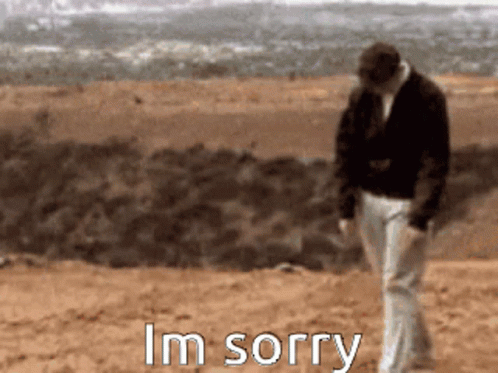 A Man Walking On A Dirt Road With The Words I 'M Sorry Written Below Him GIF