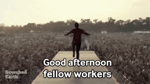 a man walking on a stage with the words good afternoon fellow workers