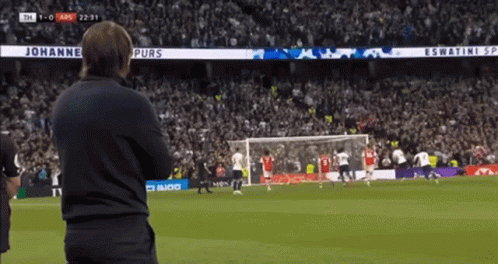 A Man Watches A Soccer Game With A Banner That Says Johannes Purs On It GIF