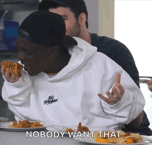 A Man Wearing A 100 Thieves Sweatshirt Is Eating A Slice Of Pizza GIF