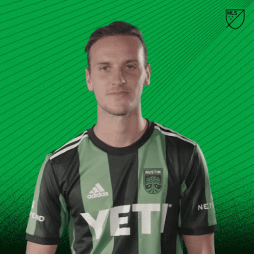 A Man Wearing A Austin Jersey Says Vamos On A Green Background GIF